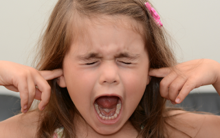 Girl screaming with fingers in her ears