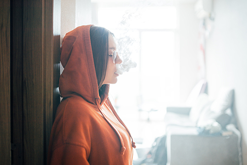 girl smokes vaporizer exhaling a lot of steam